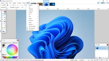 Captura da tela principal do Paint.Net. A imagem de fundo padrão do Windows 11 está carregada no programa que está exibindo várias de suas funcionalidades. Estão sendo exibidas as interfaces de camada, de cores e de ferramentas. Além disso, o menu 